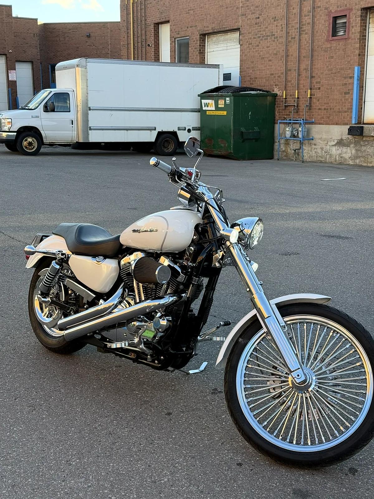 Custom cruiser motorcycle with a chrome spoke wheel detailed at Cosmo Car Customs