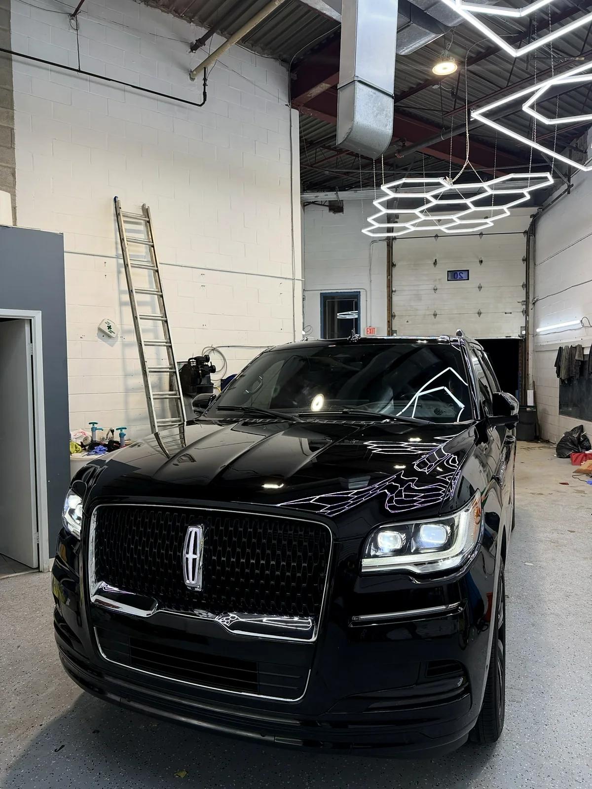 Black Lincoln Navigator detailed under the hex lights at Cosmo Car Customs
