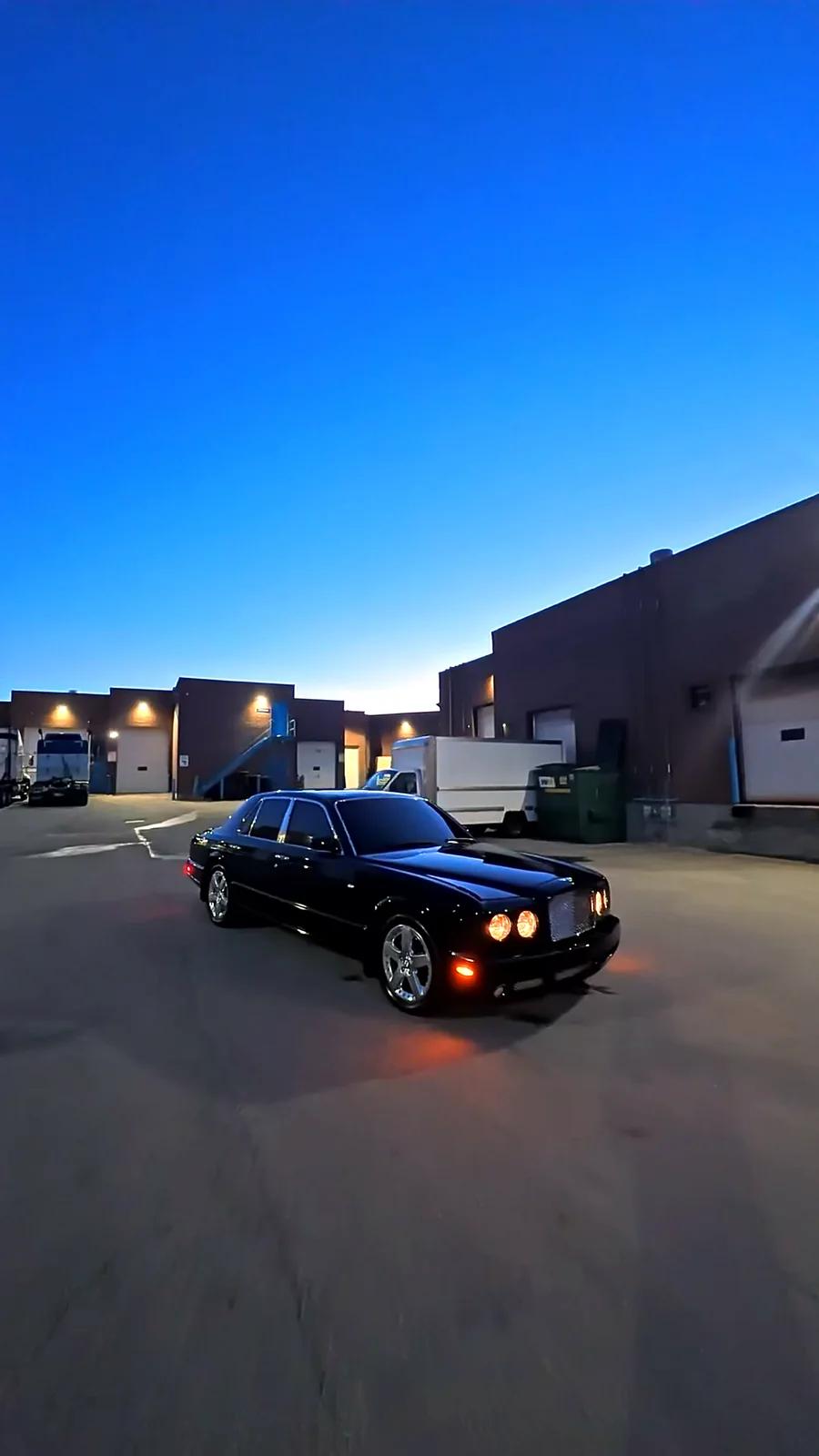 Black luxury sedan gleaming at dusk outside the Cosmo Car Customs Mississauga studio