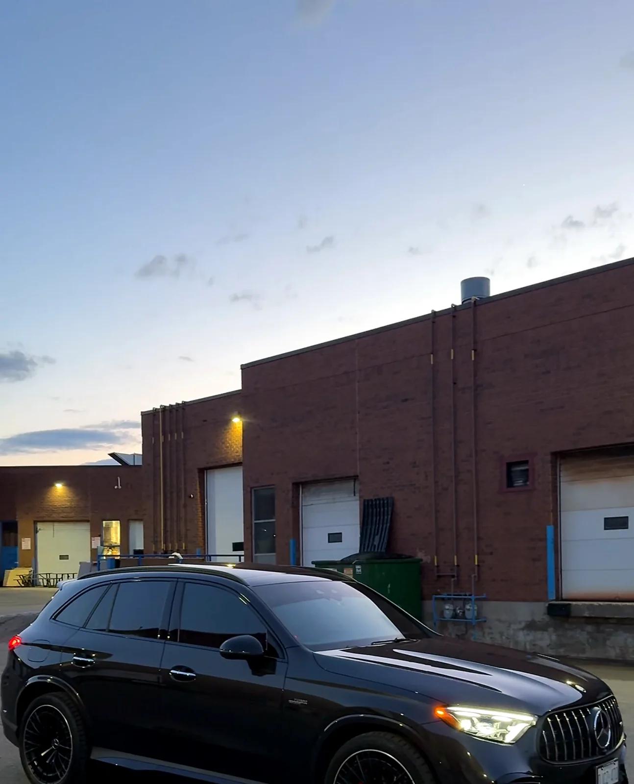Black Mercedes-Benz SUV at dusk outside the Cosmo Car Customs Mississauga shop