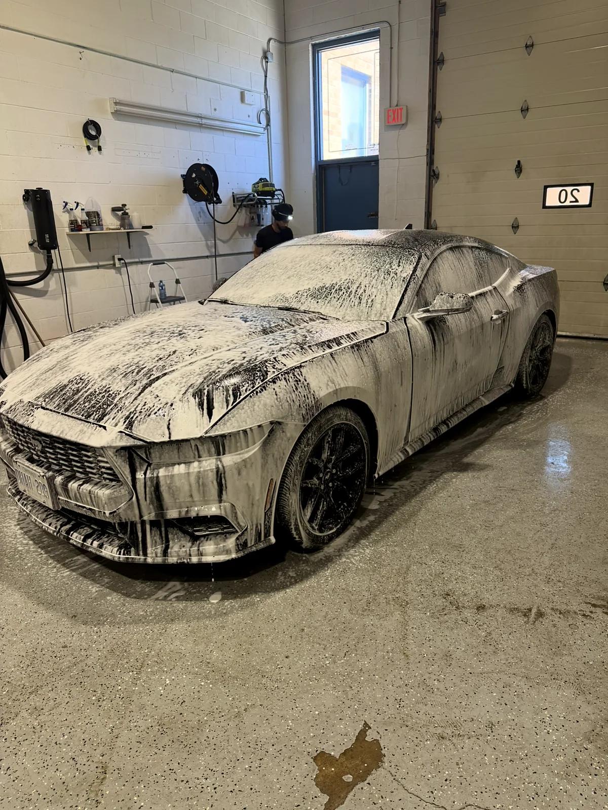 Ford Mustang covered in snow foam during a decontamination wash in Mississauga