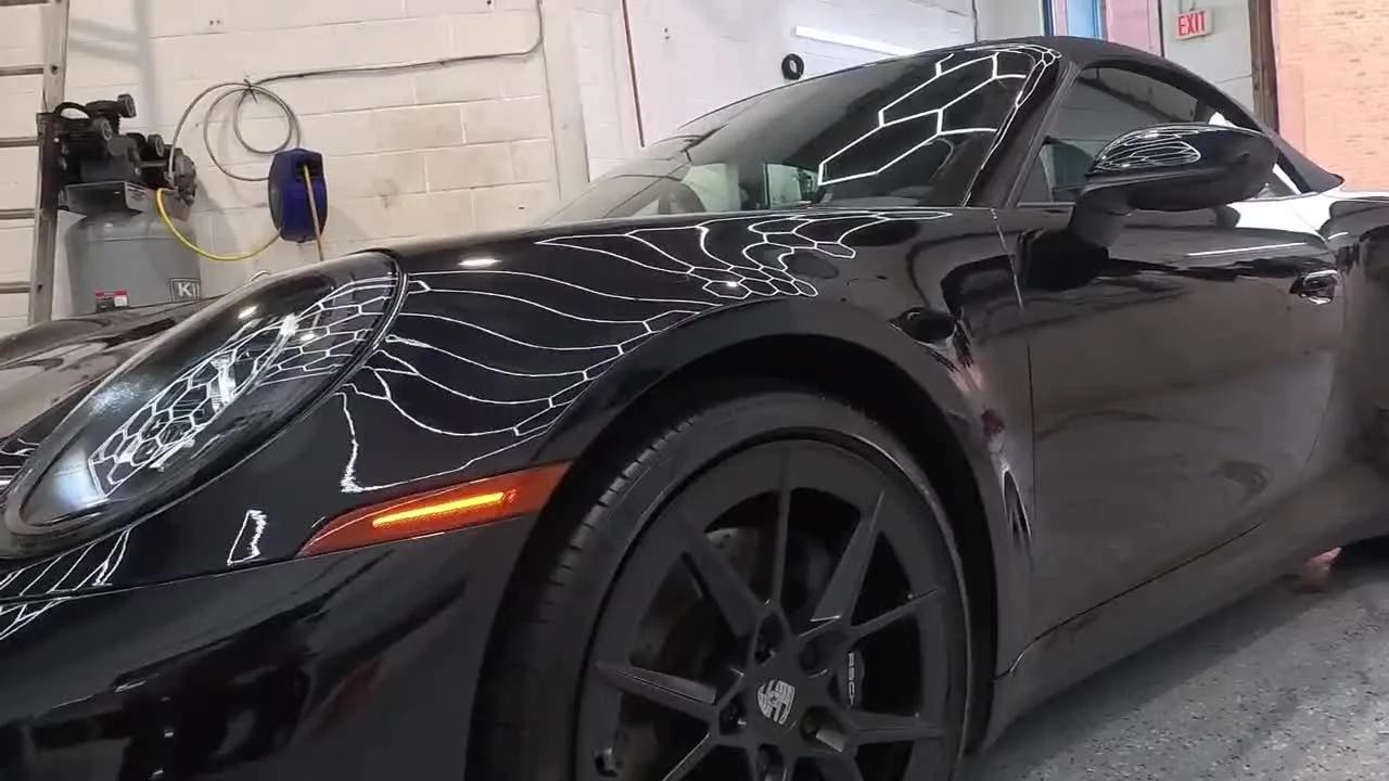 Inside the Cosmo Car Customs studio in Mississauga, a black Porsche 911 being detailed