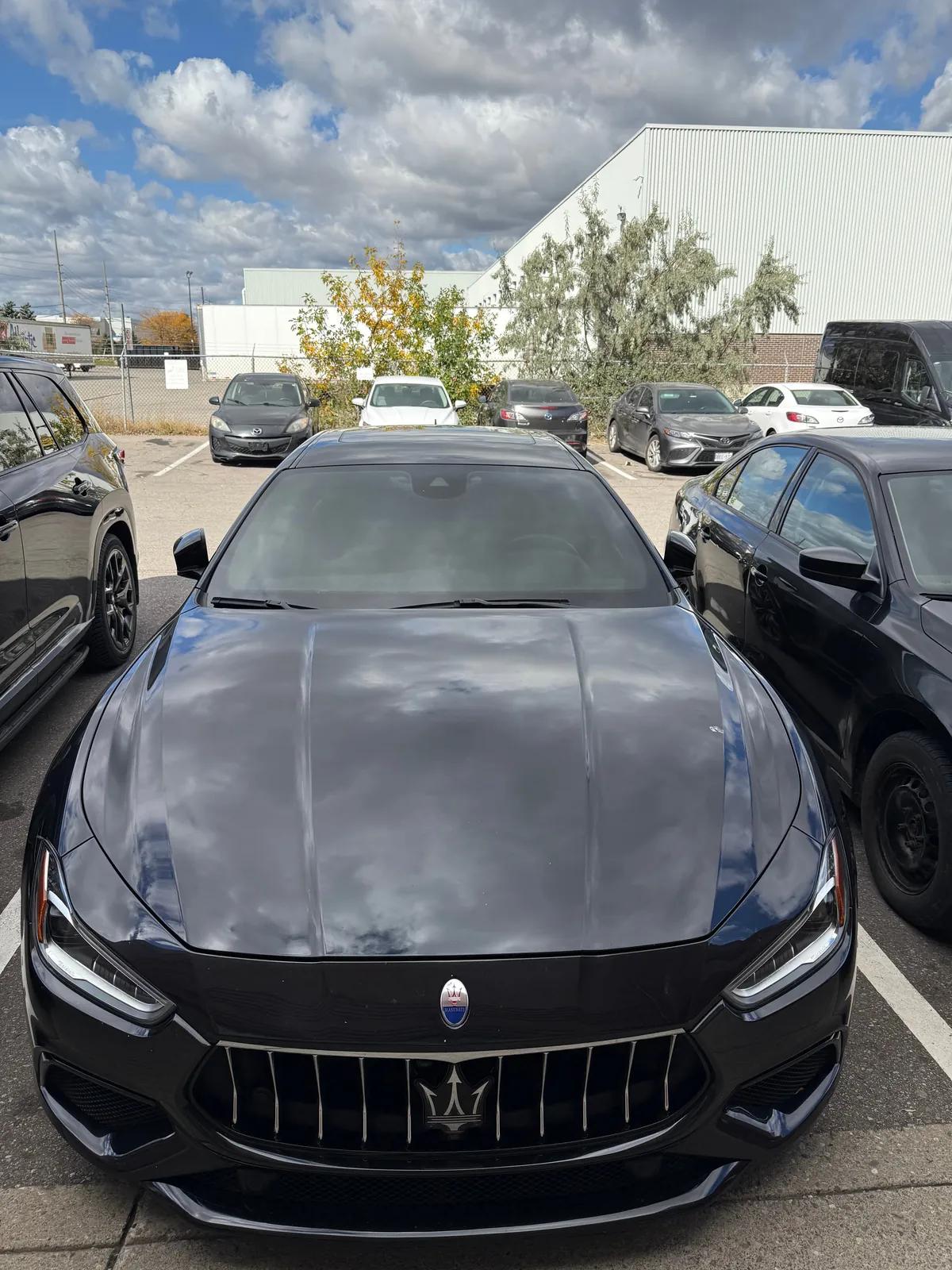 Black Maserati Ghibli outside the Mississauga studio with clouds reflecting in the freshly detailed hood