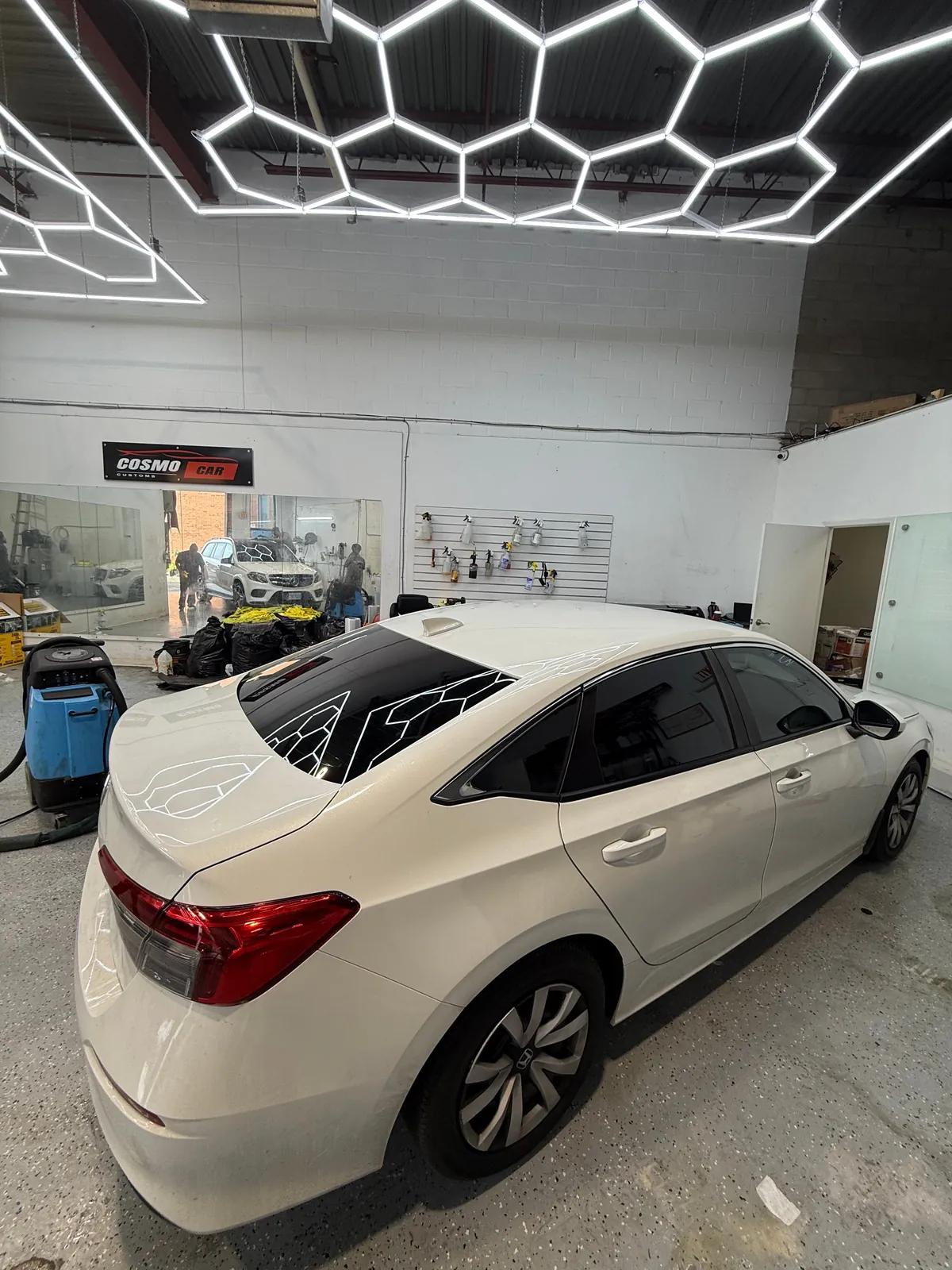 White Honda Civic with freshly tinted side windows and back windshield in the Cosmo Car Customs studio