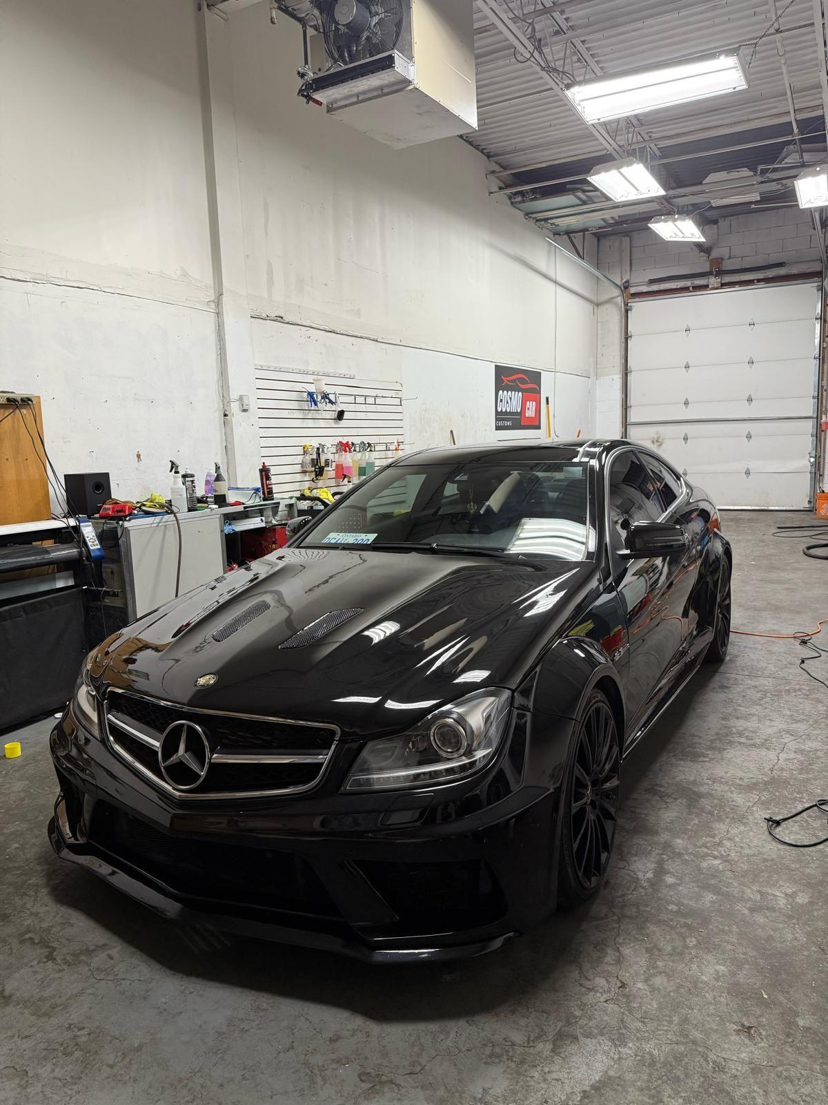 Paint correction in progress under inspection lights at Cosmo Car Customs