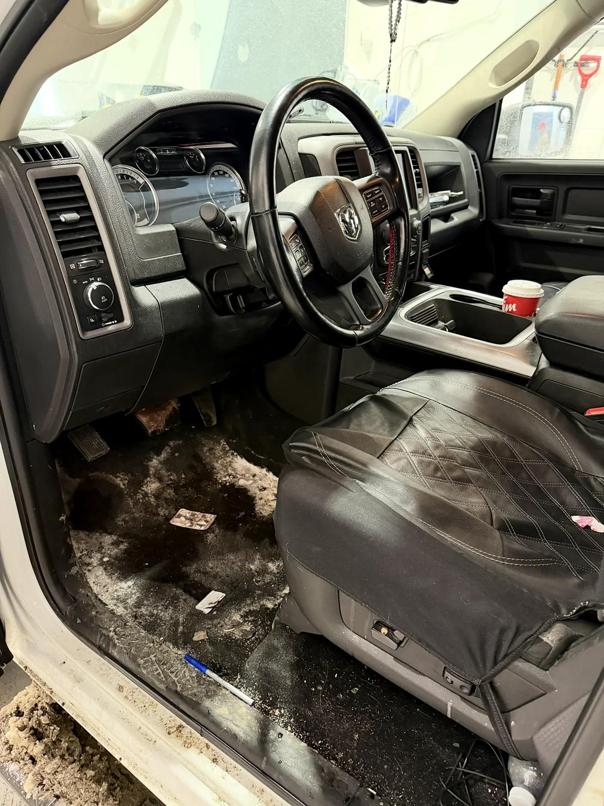 Ram pickup driver footwell caked in mud before an interior detail