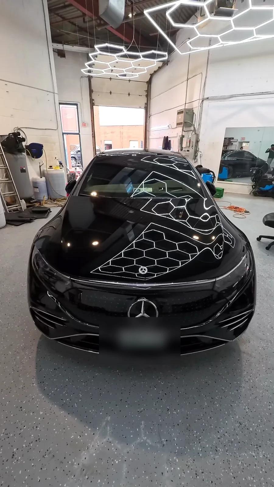 Black Mercedes EQS reflecting the studio hex lights after ceramic coating