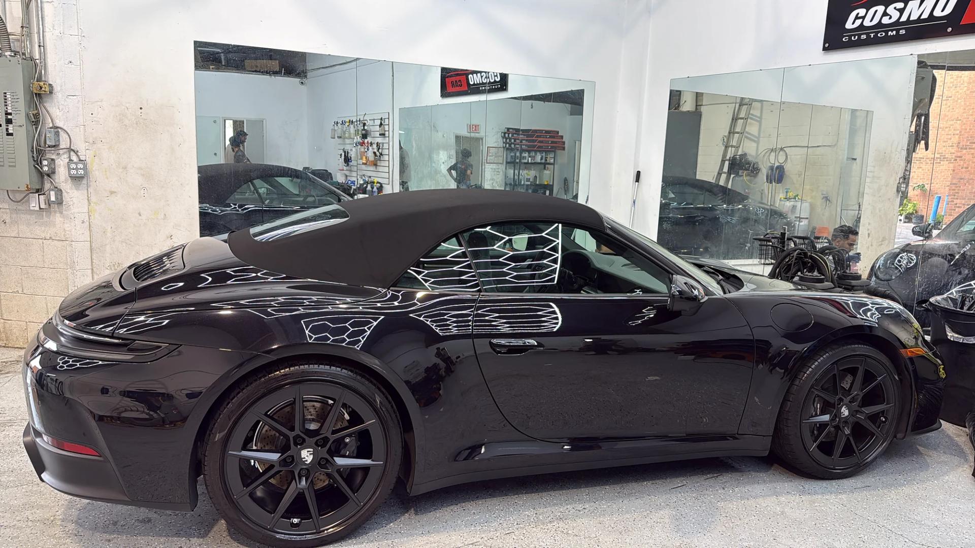 Side view of the finished black Porsche 911 Cabriolet inside the Cosmo Car Customs studio