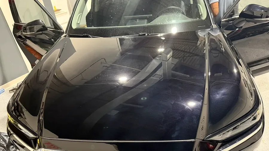 Glossy black Toyota hood reflecting the studio lights after a detail at Cosmo Car Customs