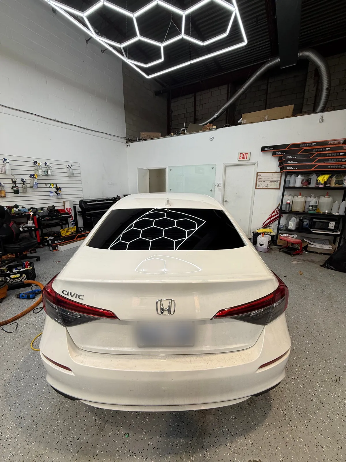 Rear view of the same white Honda Civic with a tinted back windshield